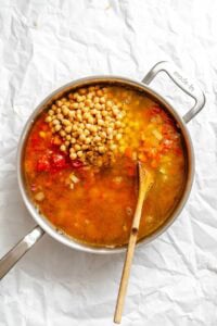 Process shot showing stirring ingredients in pot.