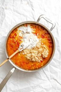 Process shot showing stirring ingredients in pot.