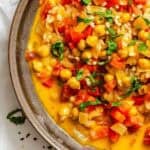 Completed Coconut Chickpea Curry Soup in pot on white surface.