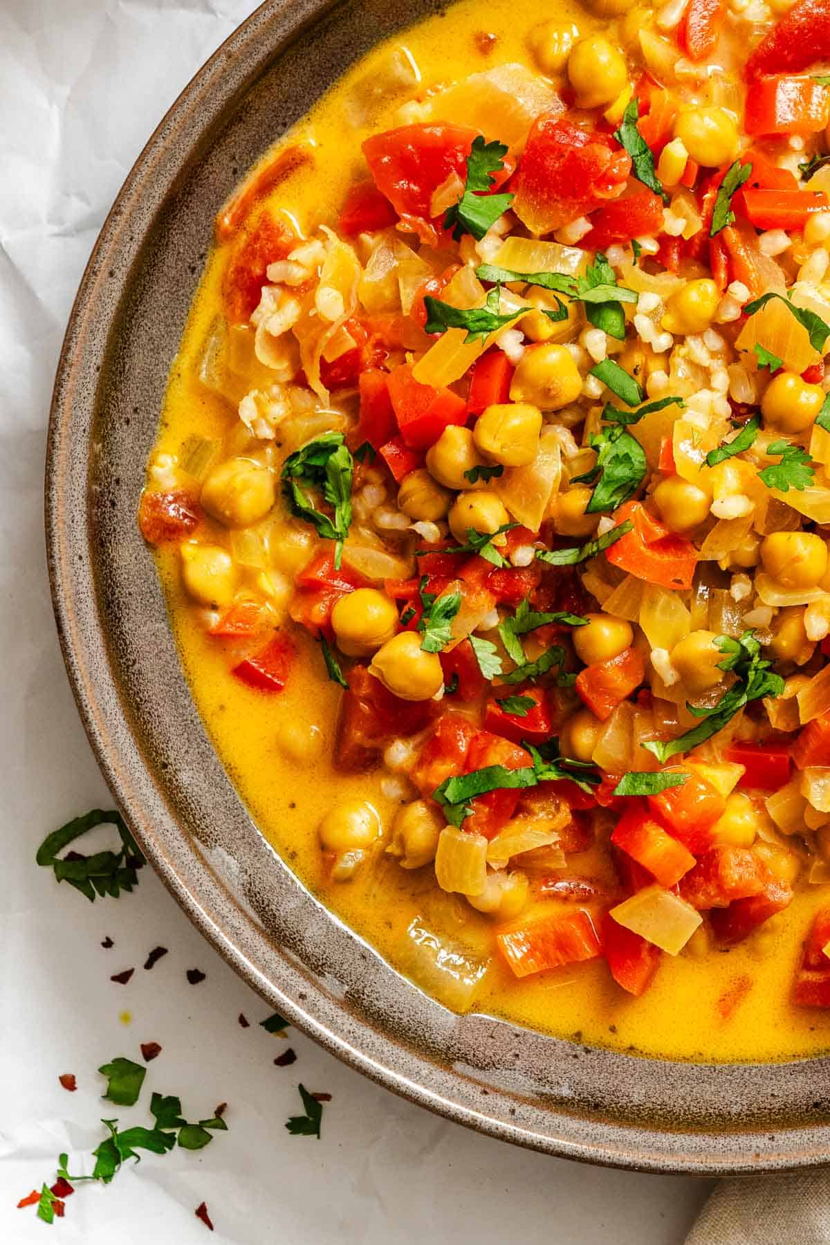 Completed Coconut Chickpea Curry Soup in pot on white surface.