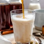 Completed Homemade Chai Concentrate in a glass and several jars.