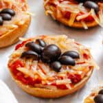Completed Mini Spider Pizza [Bagel Bites] on a white surface.