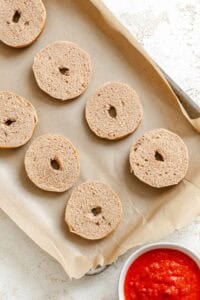 Process shot showing bagels on a baking tray.