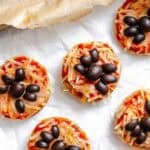 Completed Mini Spider Pizza [Bagel Bites] on a white surface.