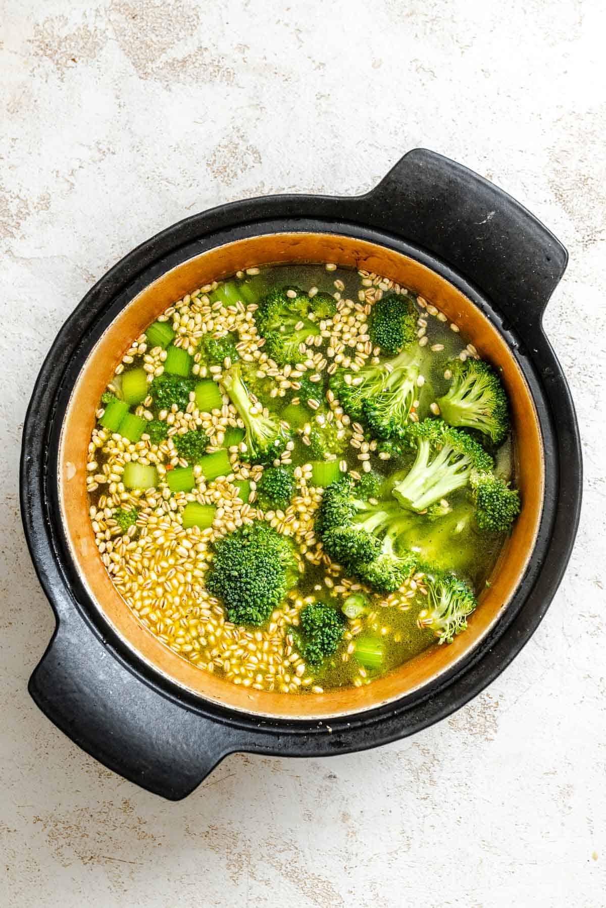 Process shot showing veggies added to pot.