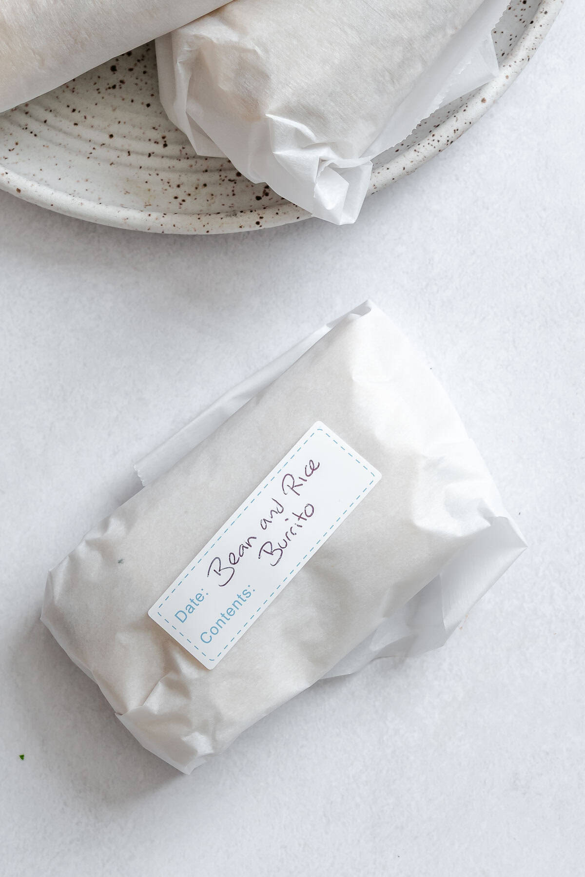 Completed Rice and Black Bean Burrito (Freezer Friendly) wrapped in parchment paper.