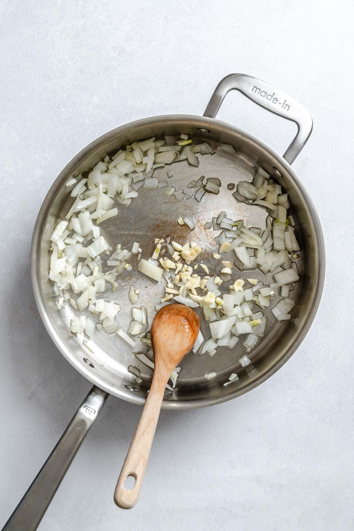 Process shot showing veggies cooking in a pot.