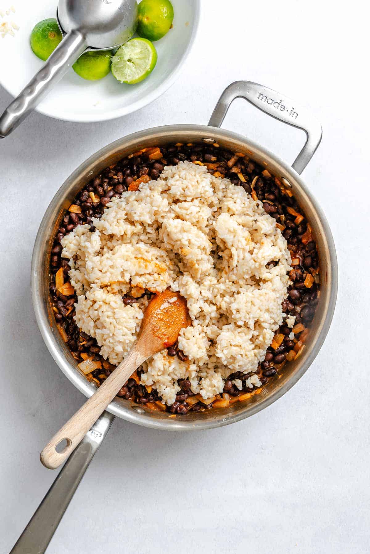 Process shot showing rice being added to pan.