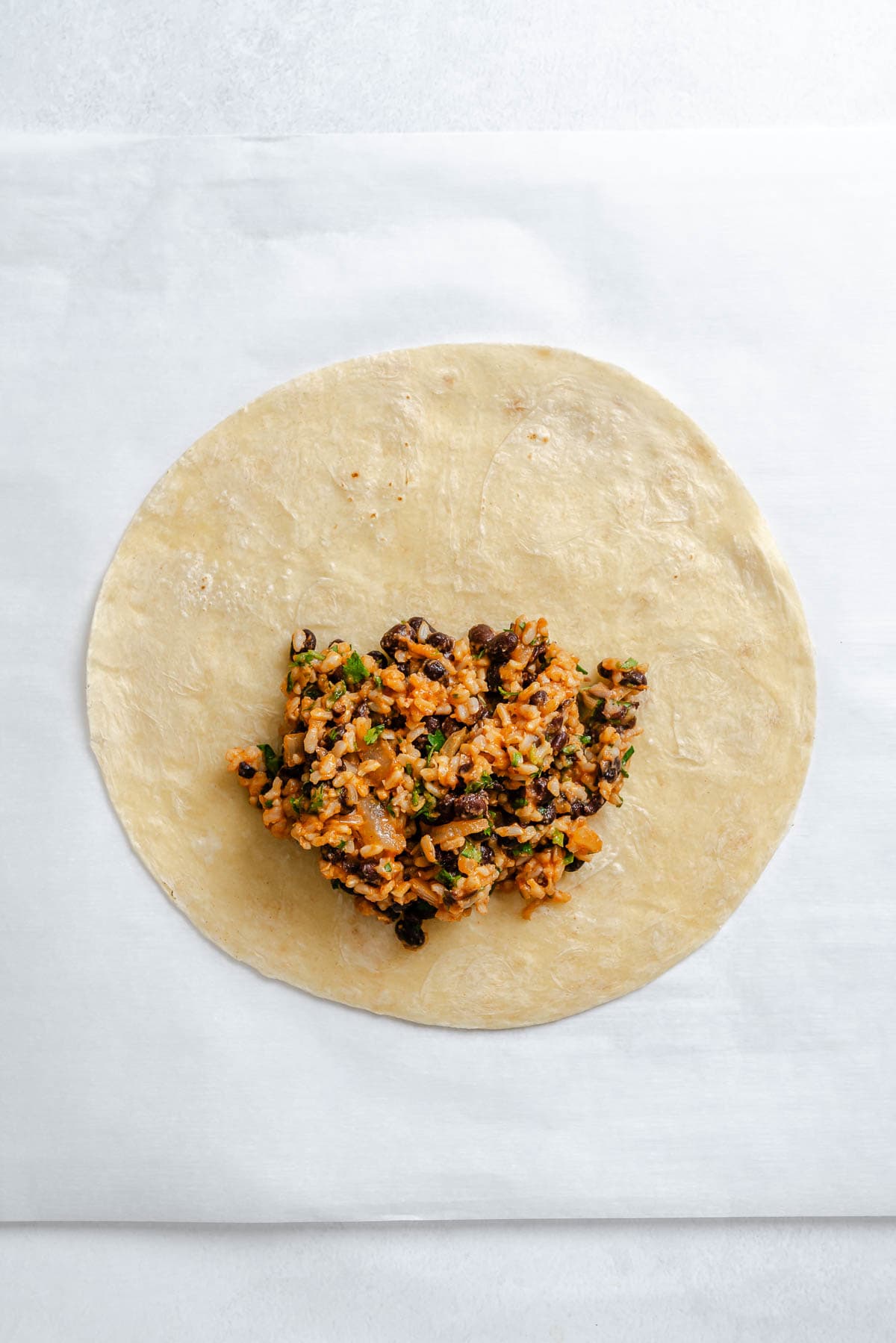 Process shot showing filling added to tortilla.