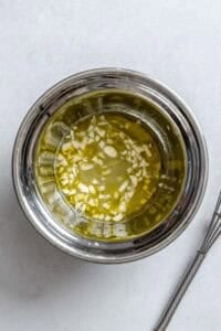 Process shot showing dressing being mixed in a bowl.