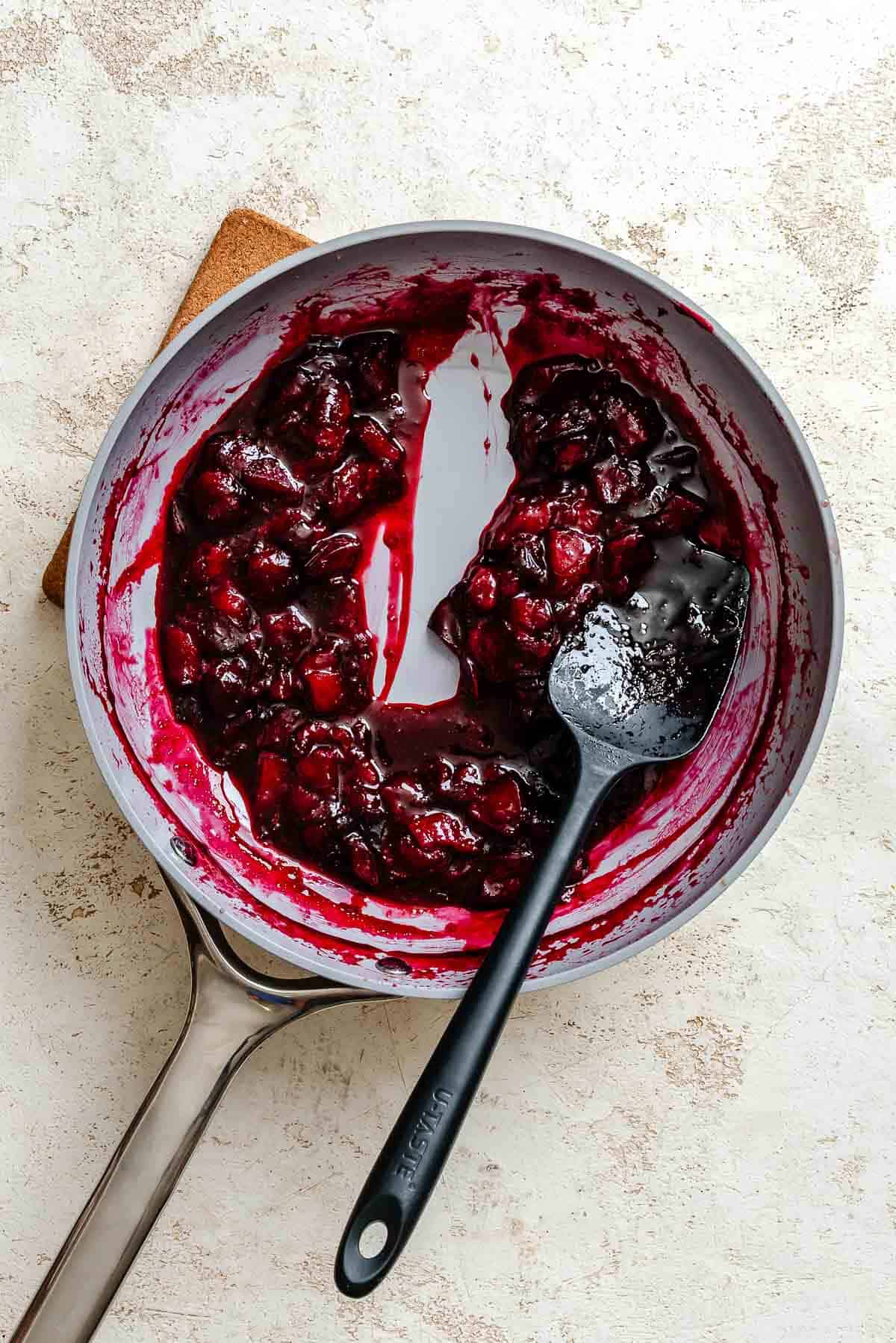 Process shot showing mixing ingredients together in pan.