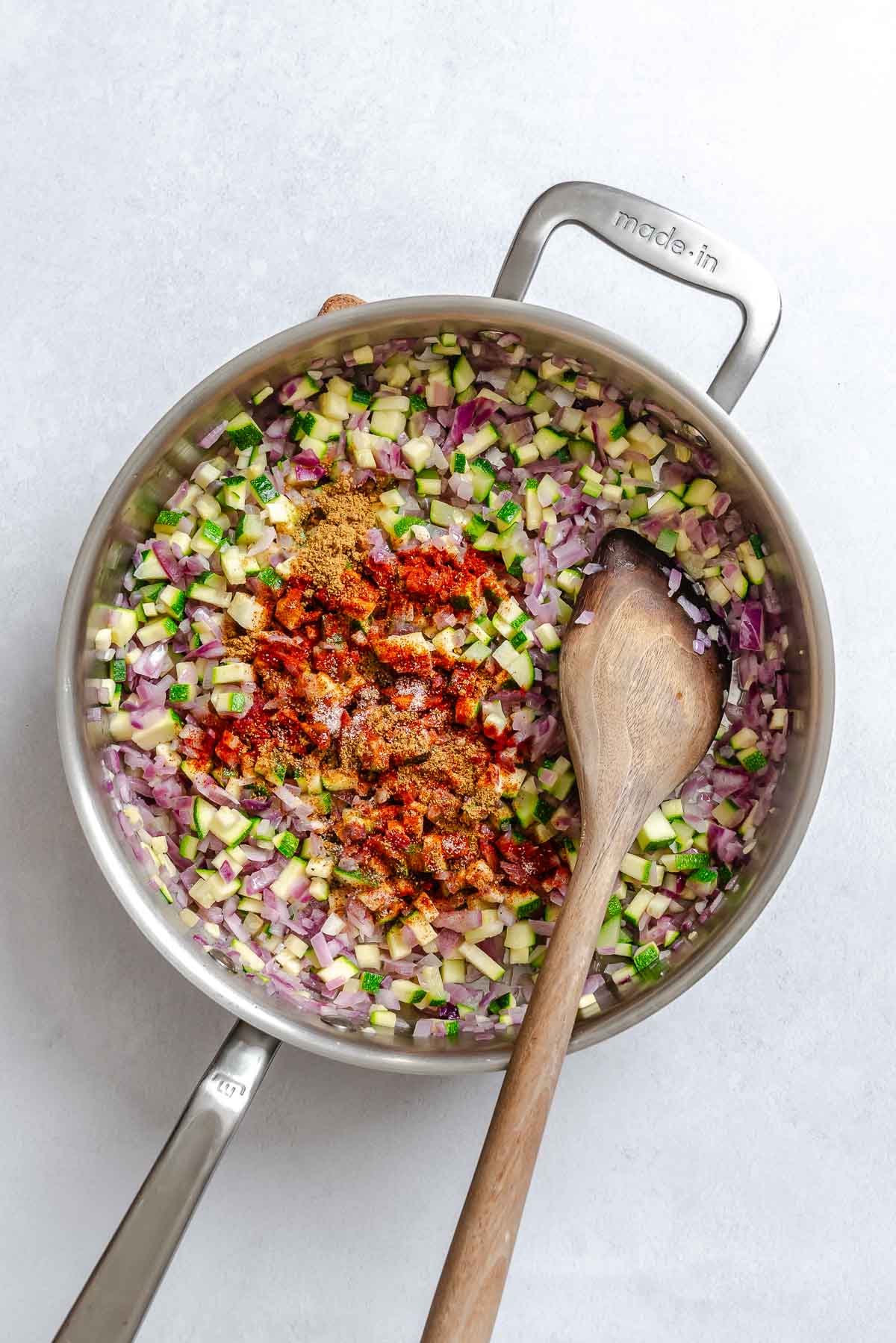 Process shot showing stirring ingredients in pot.