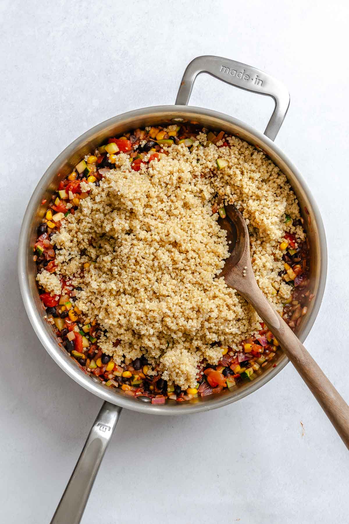 Process shot showing adding quinoa to pot.