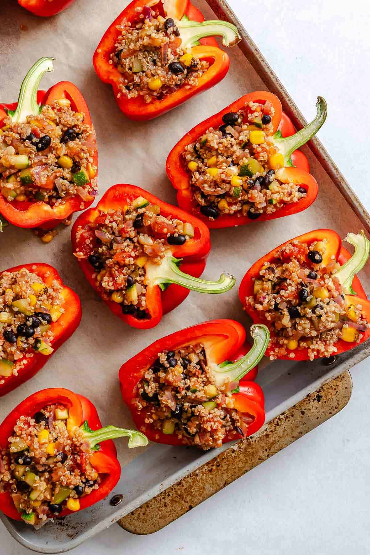 Process shot showing pre-baked Quinoa Stuffed Bell Peppers on baking tray.