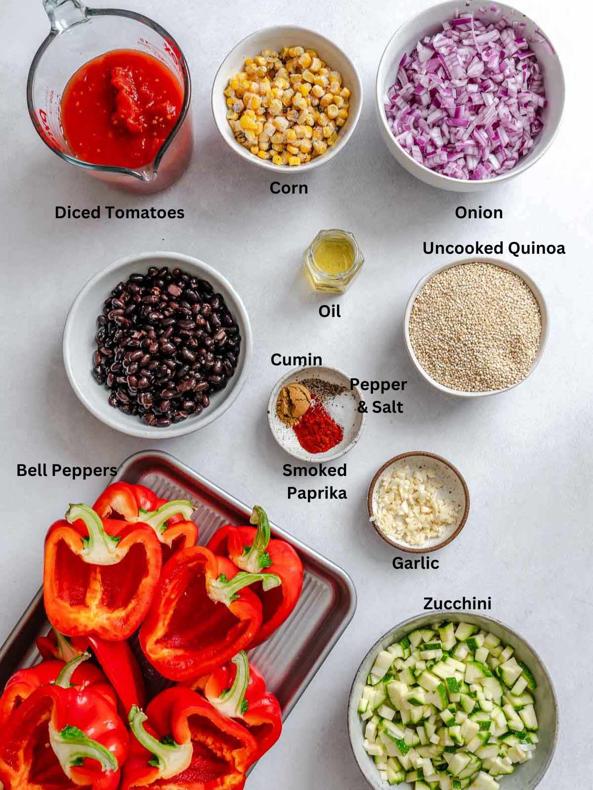 Ingredients for Quinoa Stuffed Bell Peppers measured out on a white surface.