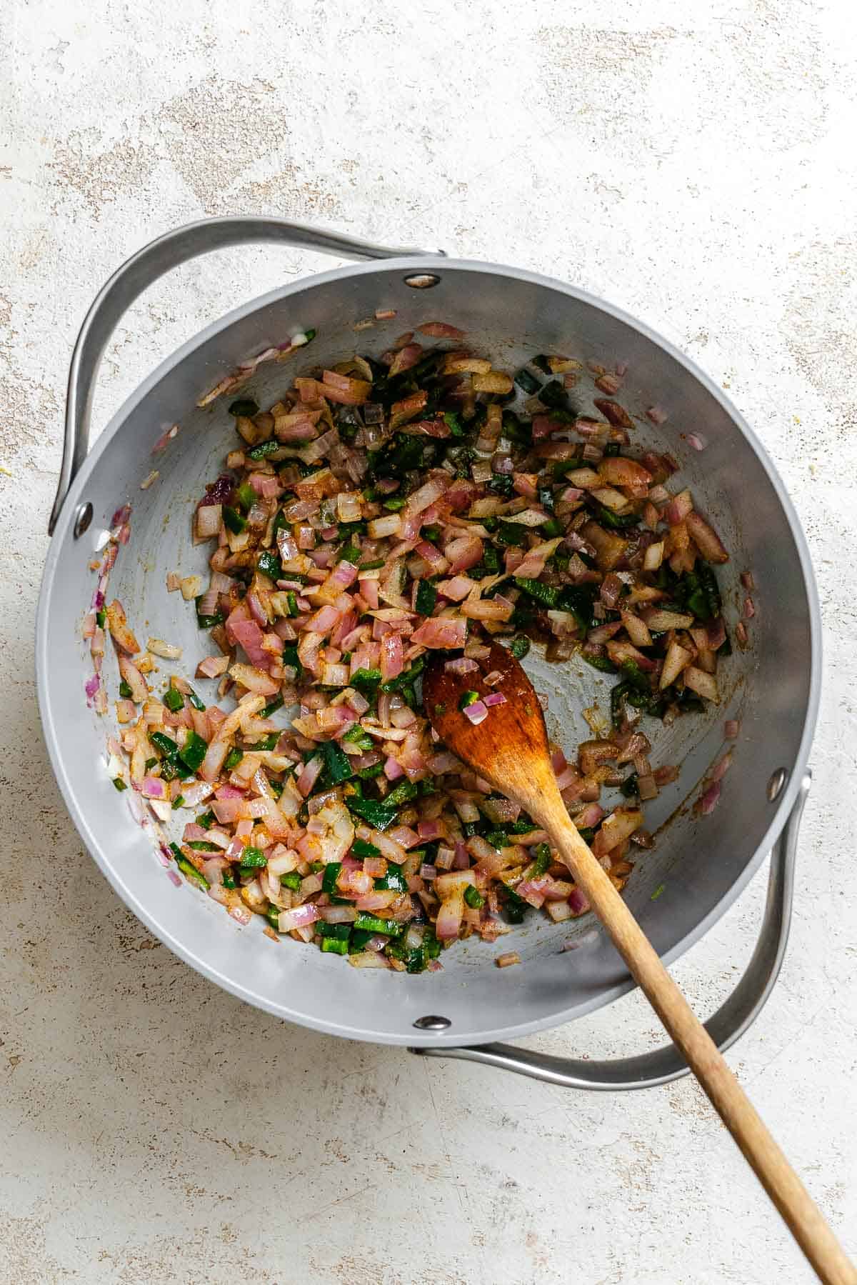 Process shot showing stirring ingredients in a pot.