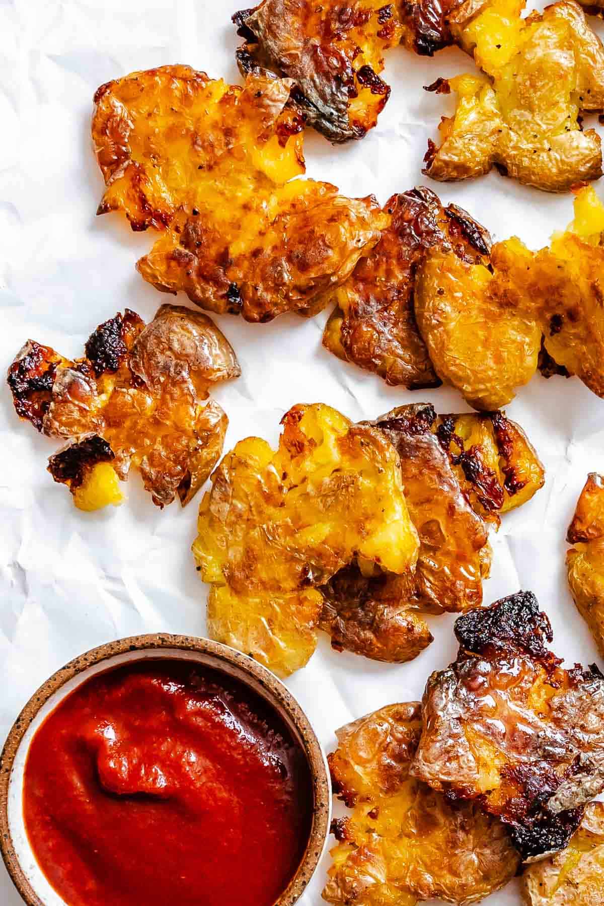 Completed Crispy Smashed Potatoes on a white surface.