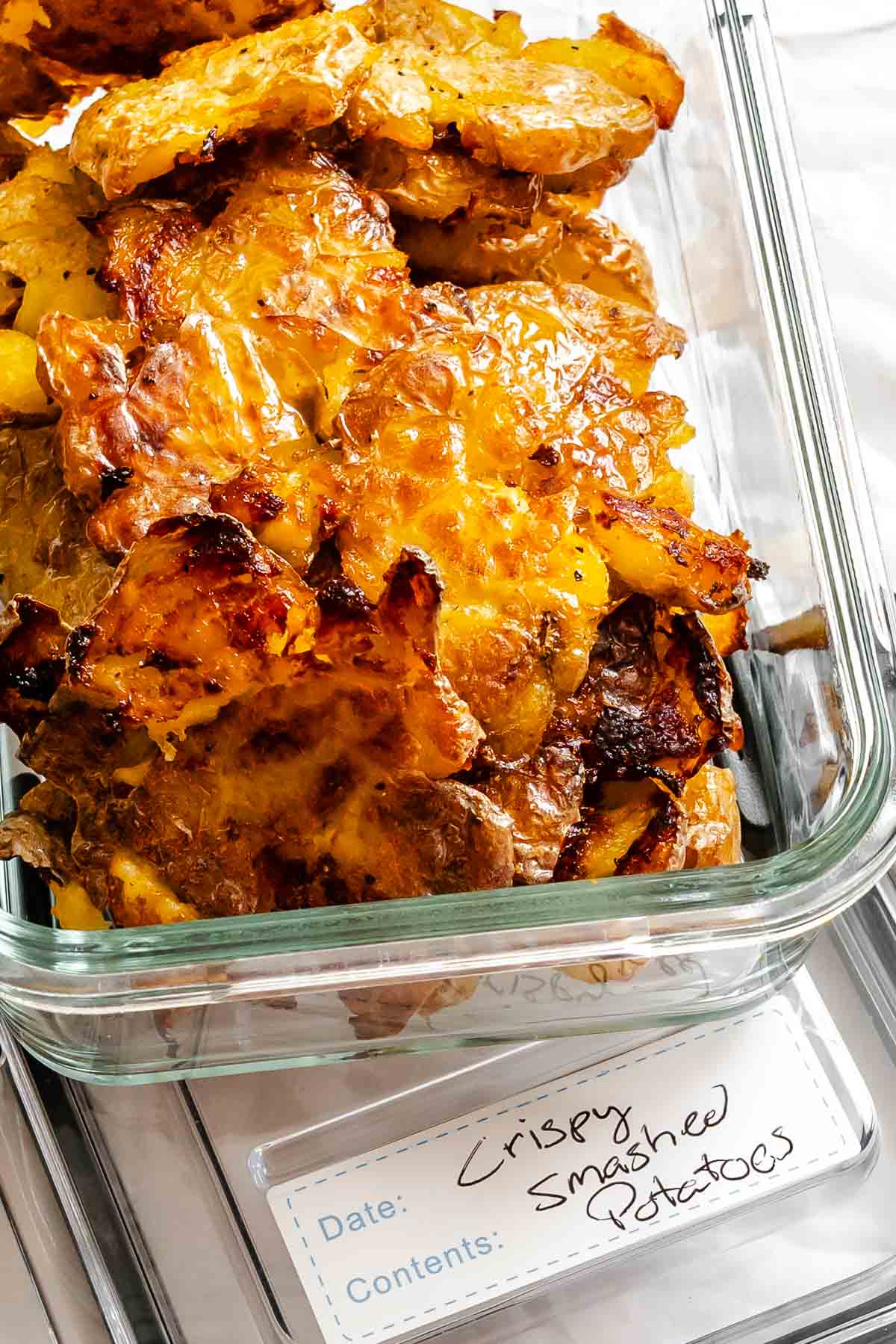 Completed Crispy Smashed Potatoes in a storage container.