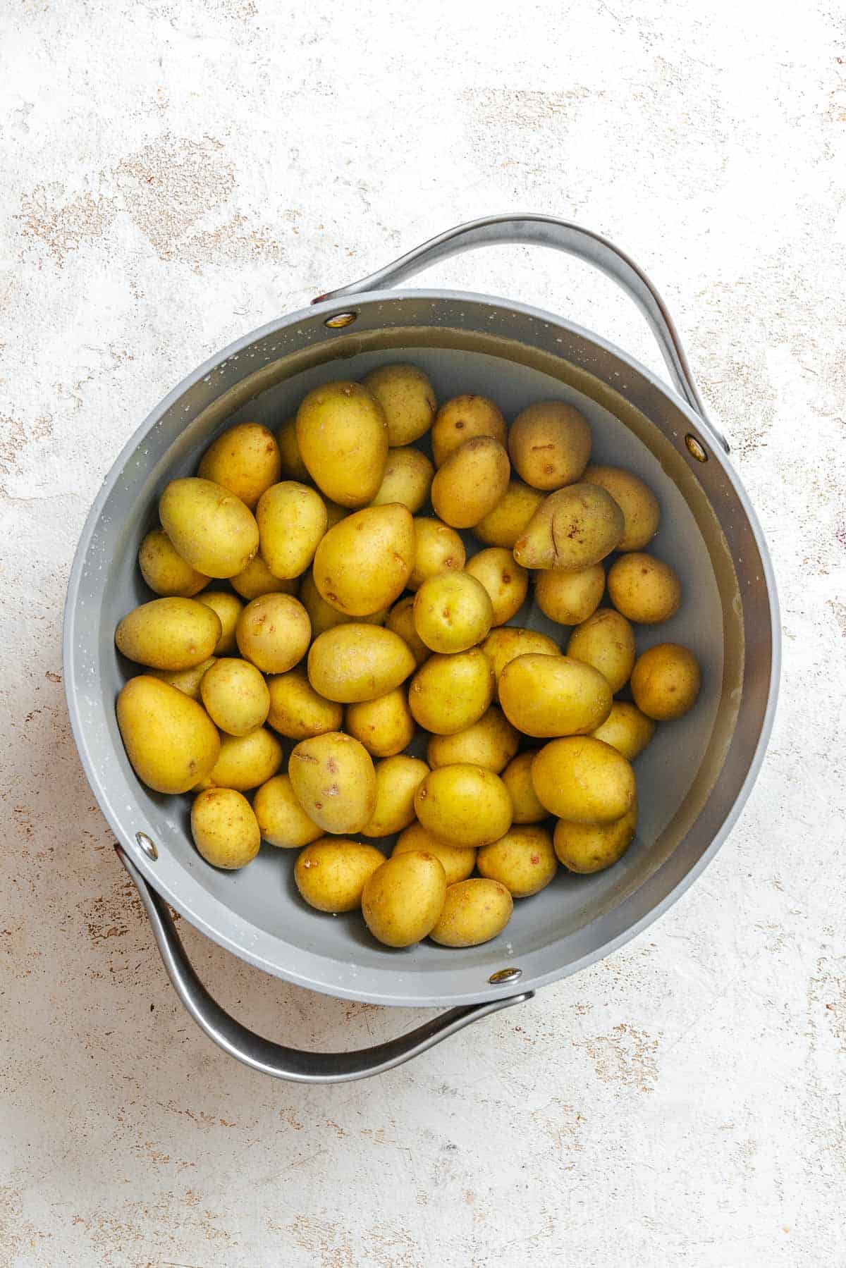 Process shot showing potatoes in a pot.