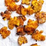 Completed Crispy Smashed Potatoes on a white surface.