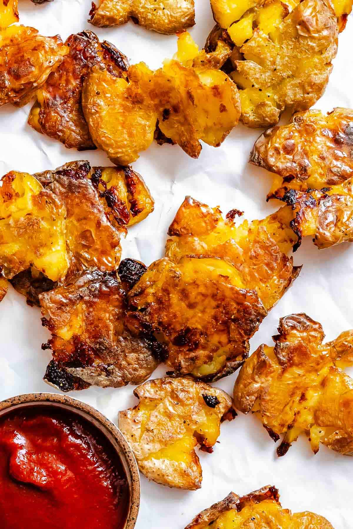 Completed Crispy Smashed Potatoes on a white surface.