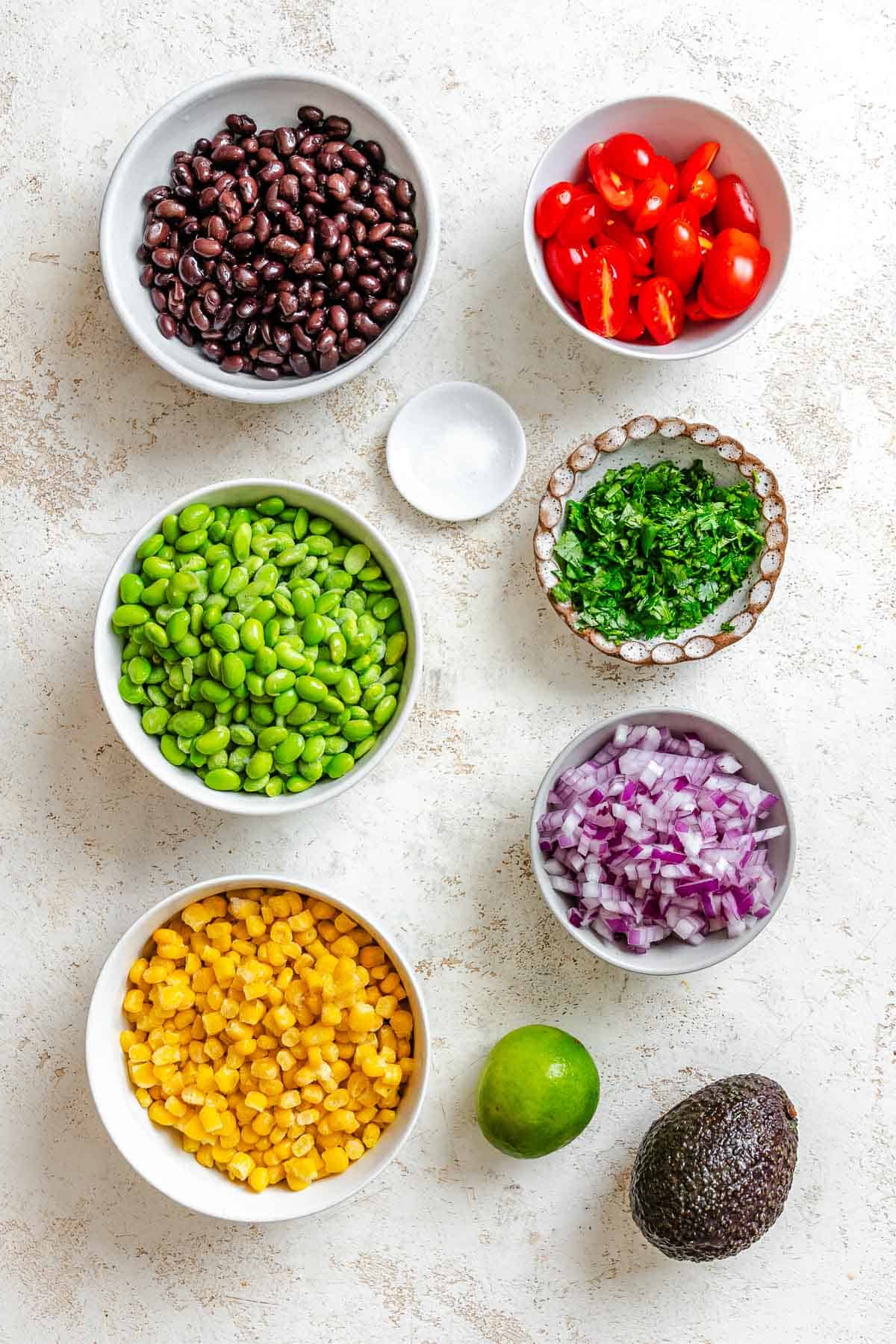 Ingredients for Edamame Salad (With Corn and Black Beans) measured out on a white surface.