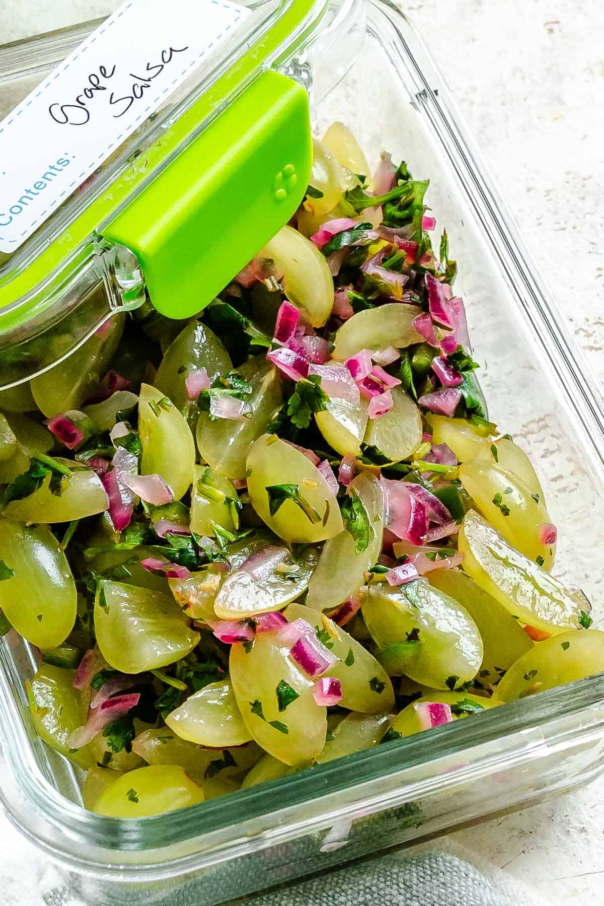 Completed Fresh Grape Salsa in a storage container.