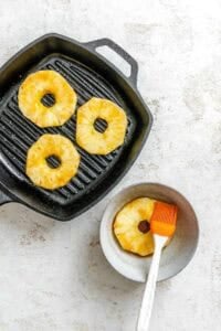 Process shot showing brushing pineapple with marinade.