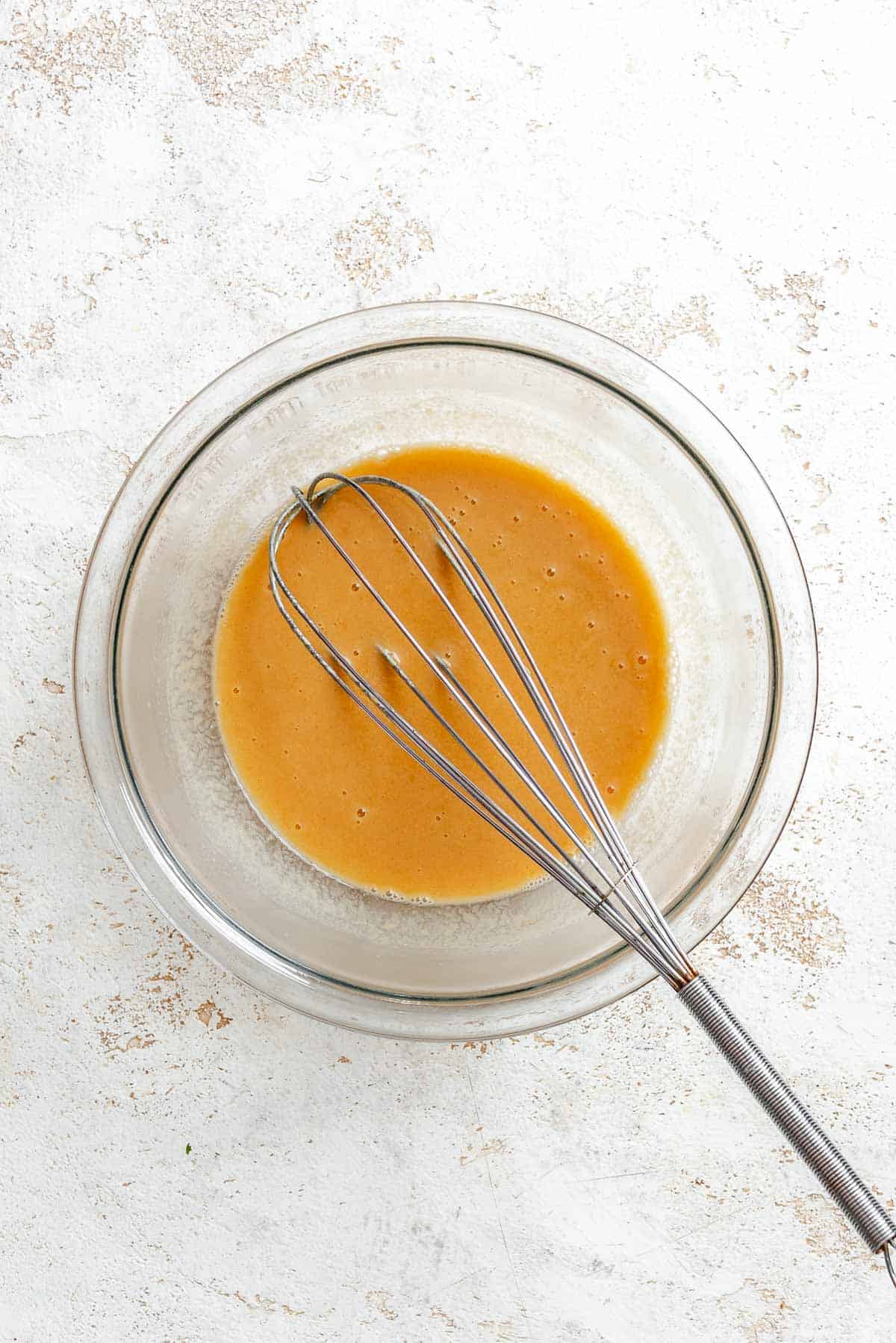 Process shot showing whisking ingredients in a bowl.