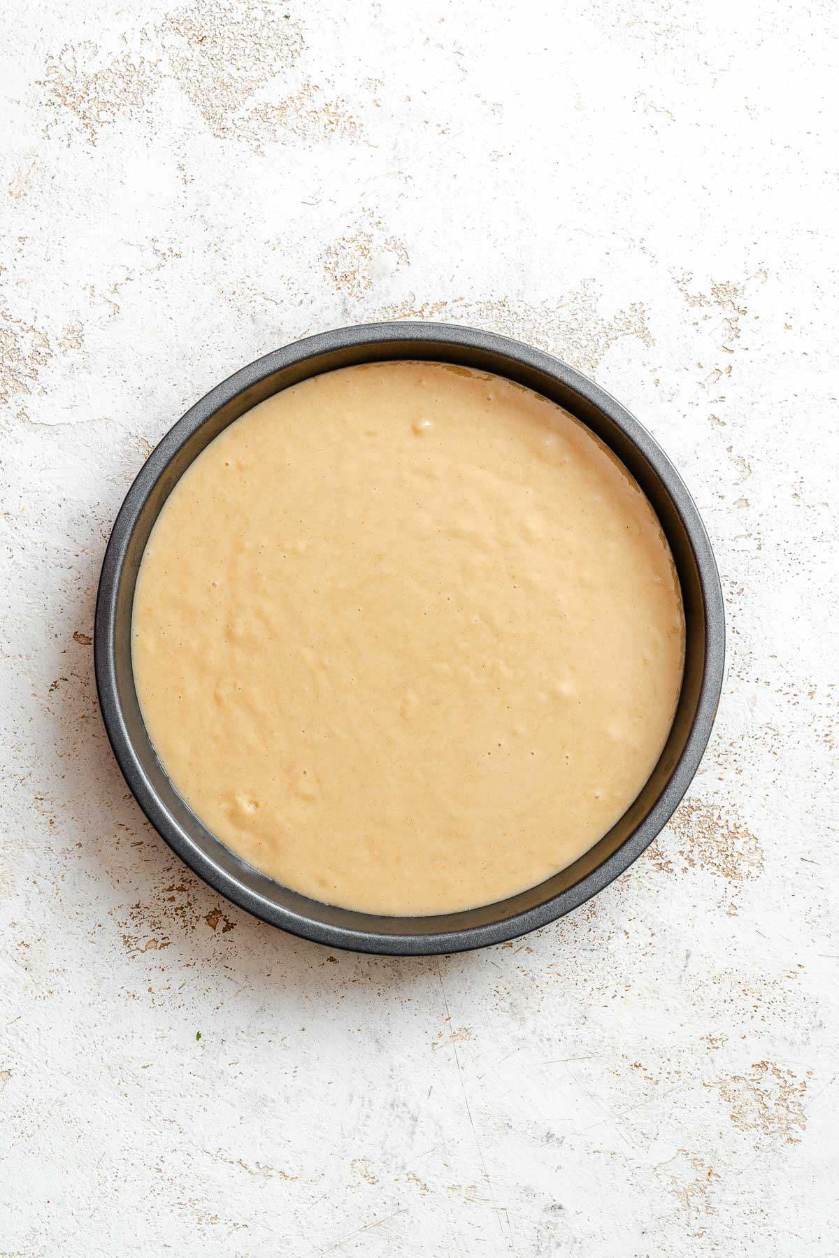 Process shot showing batter added to cake pan.
