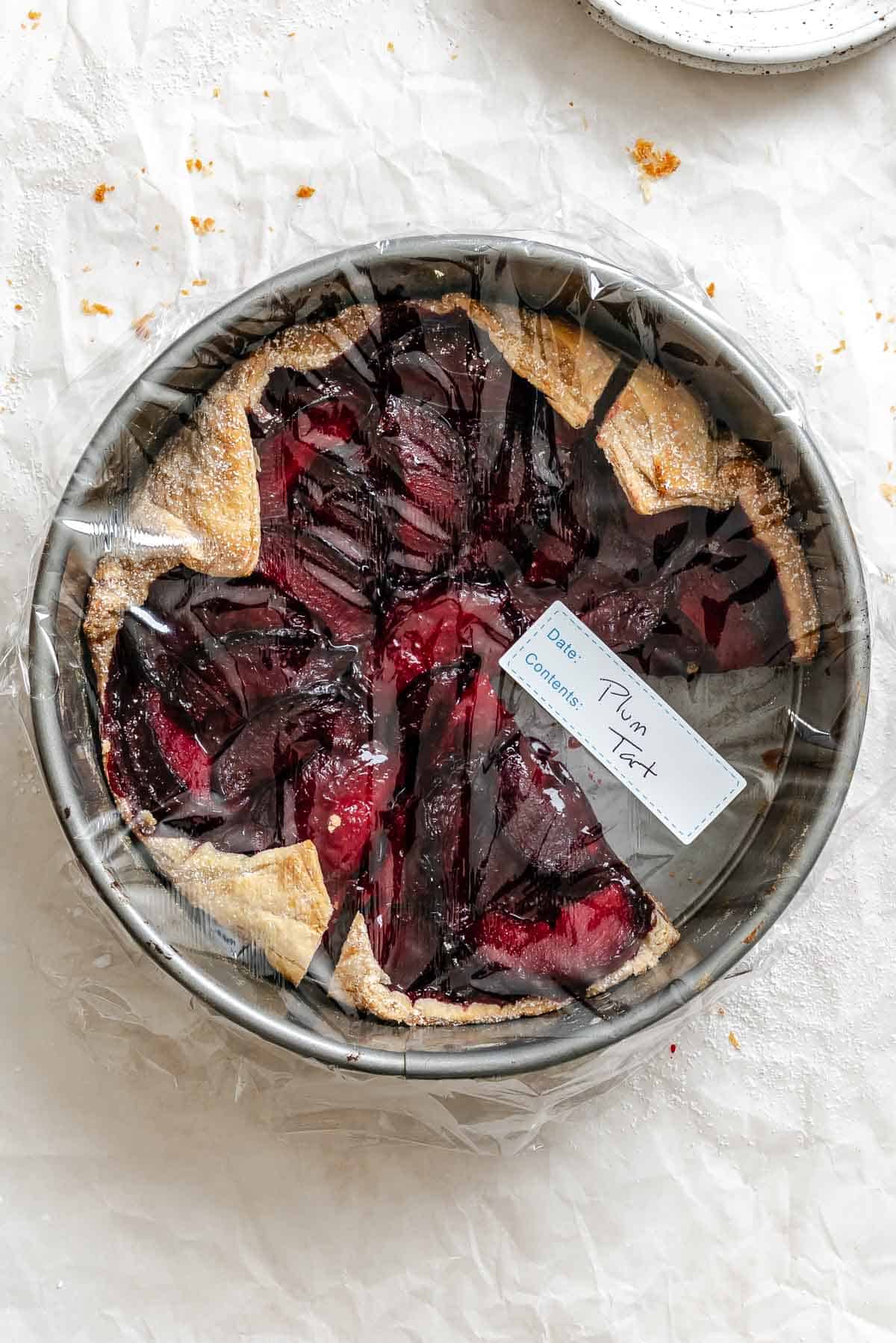 Completed Easy Plum Tart (Plum Galette) wrapped in plastic wrap.