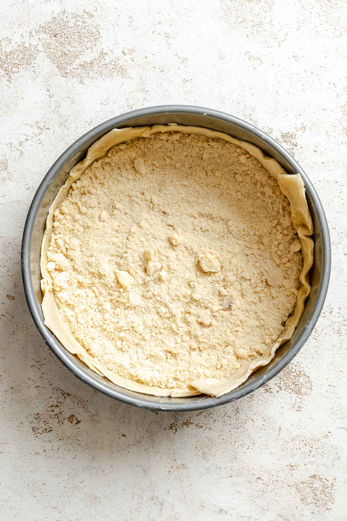Process shot showing flour mixture being added to pan.