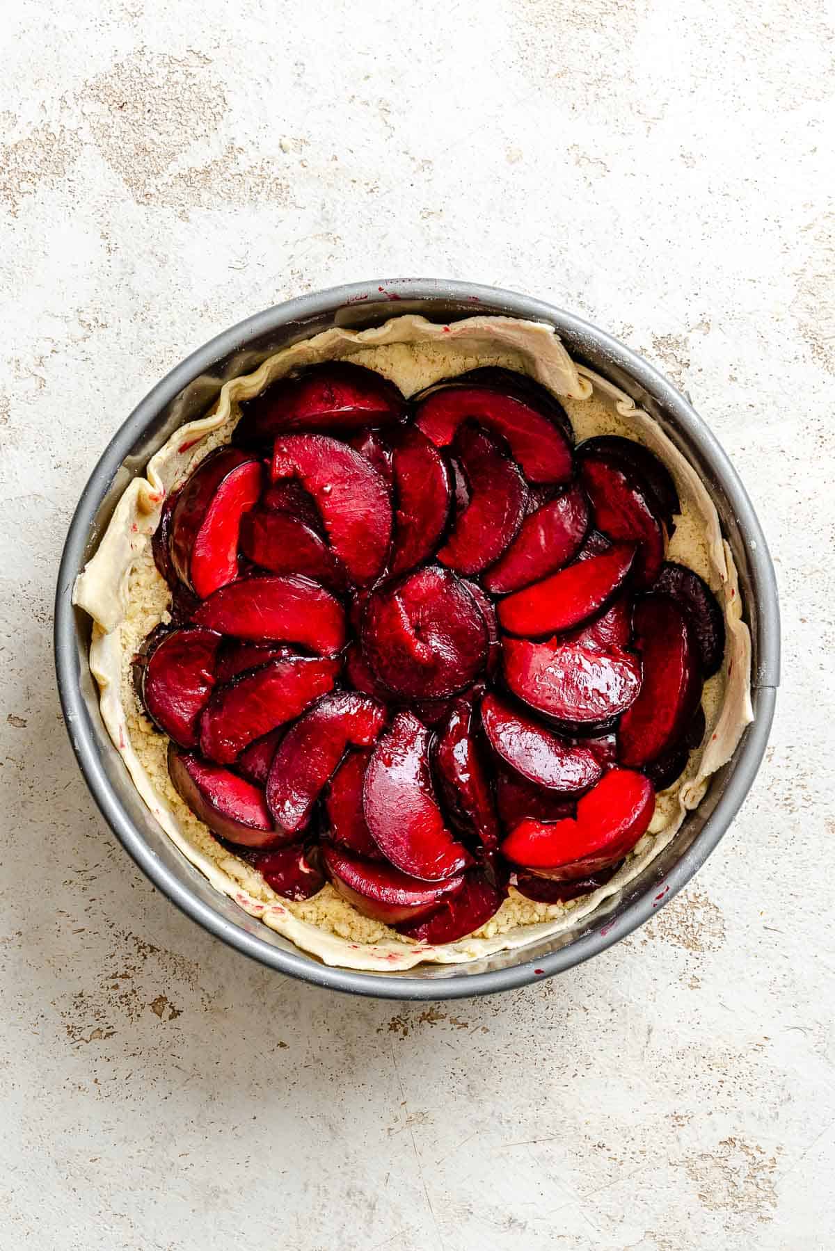 Process shot showing plum mixture added to pan.