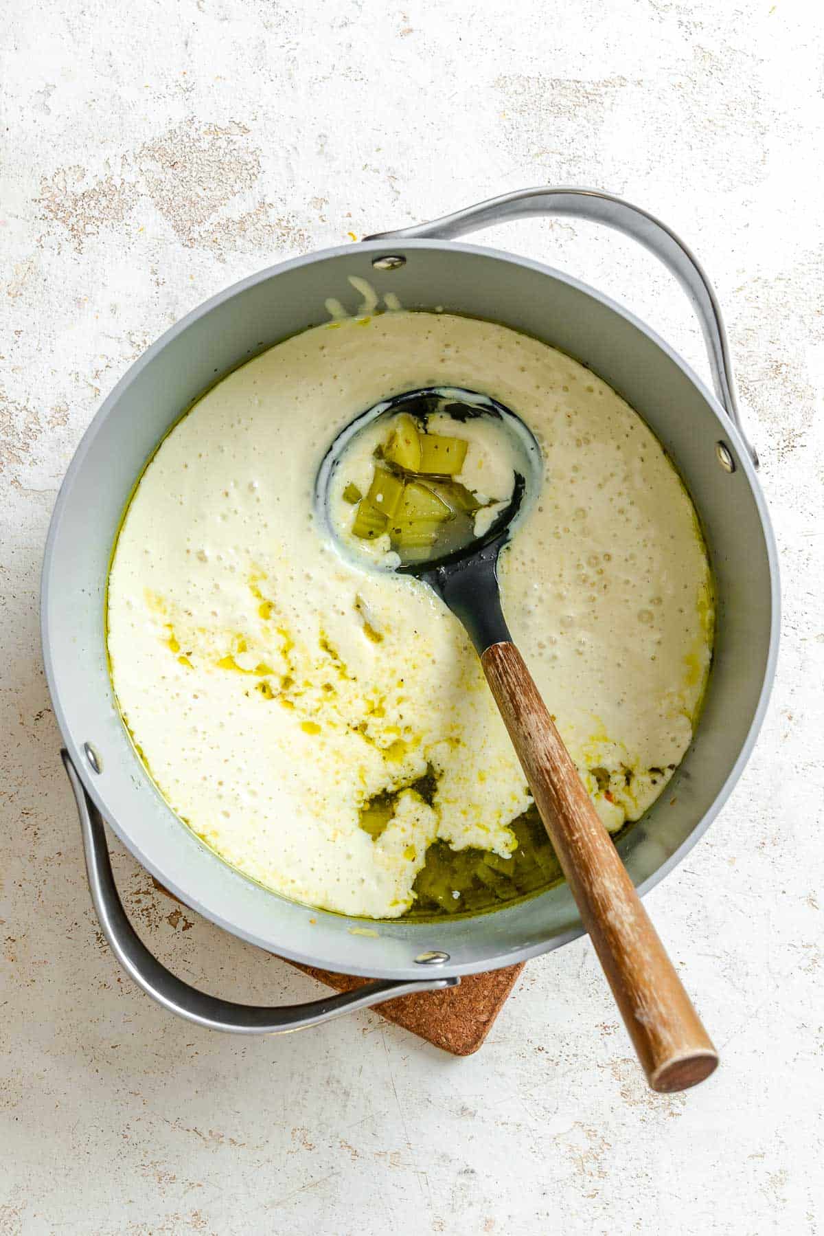 Process shot showing stirring ingredients in a pot.