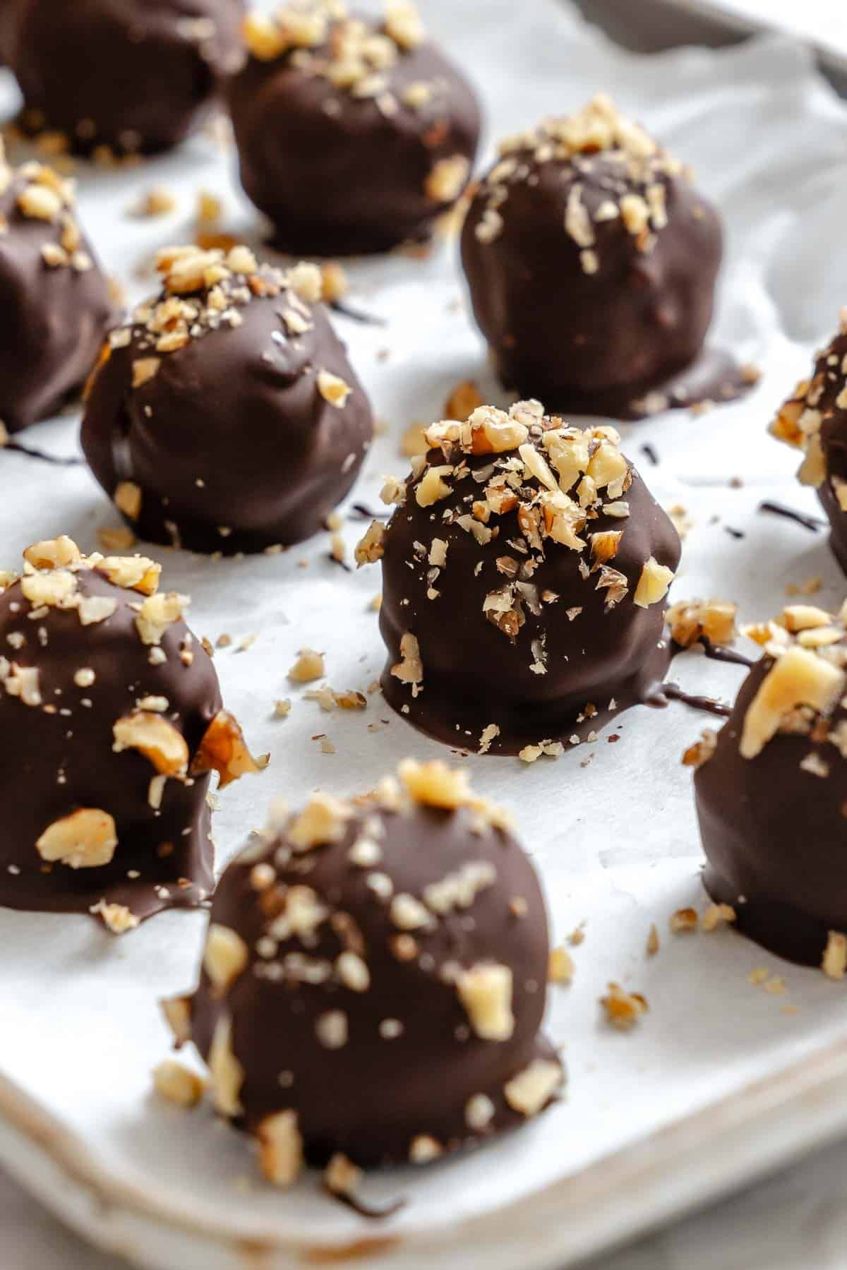 Completed Chocolate Covered Peanut Butter Balls (+ Add-Ins) on a baking sheet.