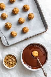 Process shot showing dipping ball into vegan chocolate.