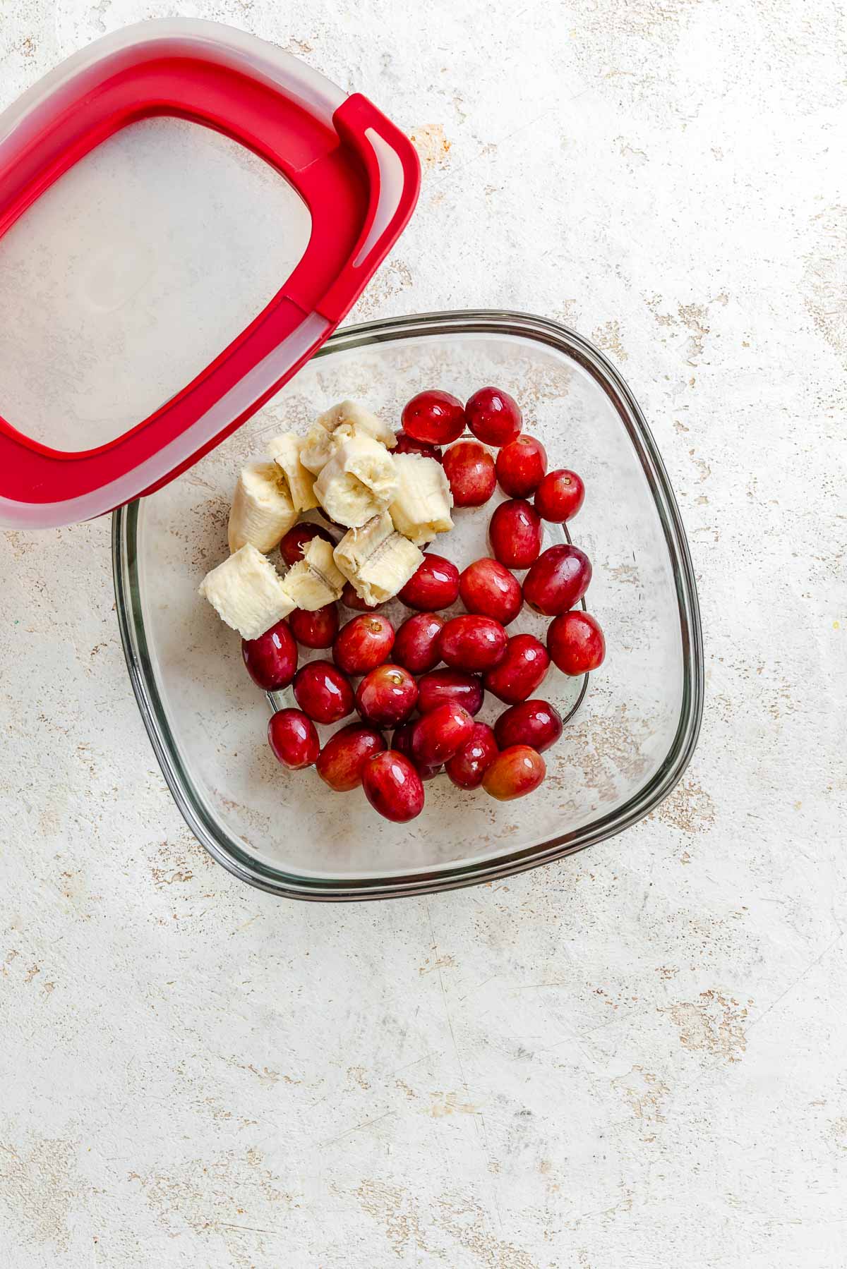 Process shot showing Easy Grape Smoothie ingredients in a container.