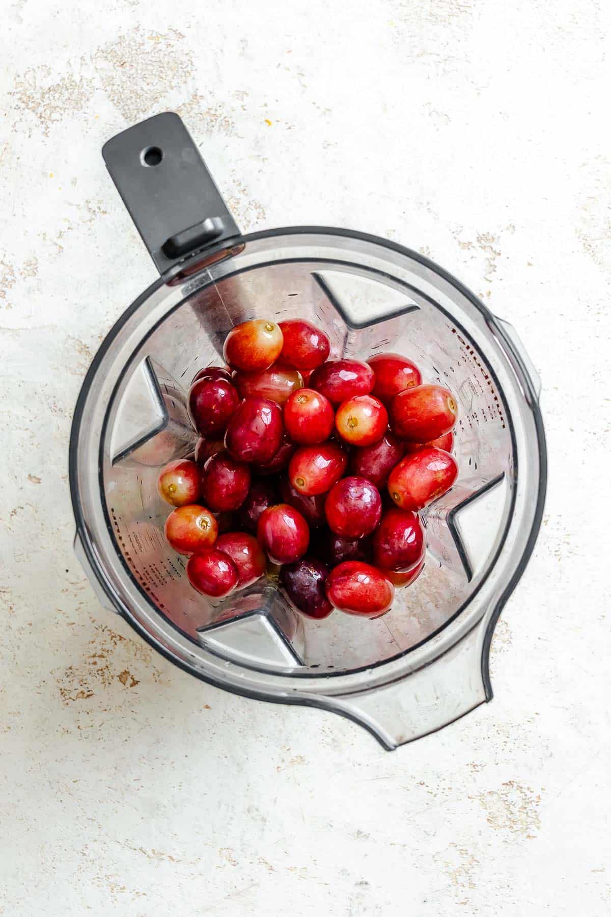 Process shot showing grapes in a blender.