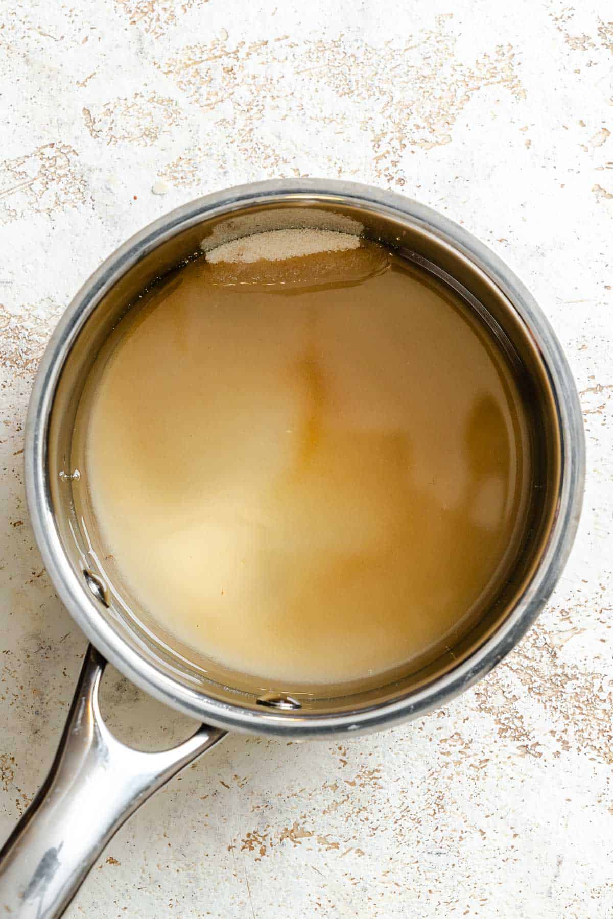 Process shot showing sugar and lemon inside pot.