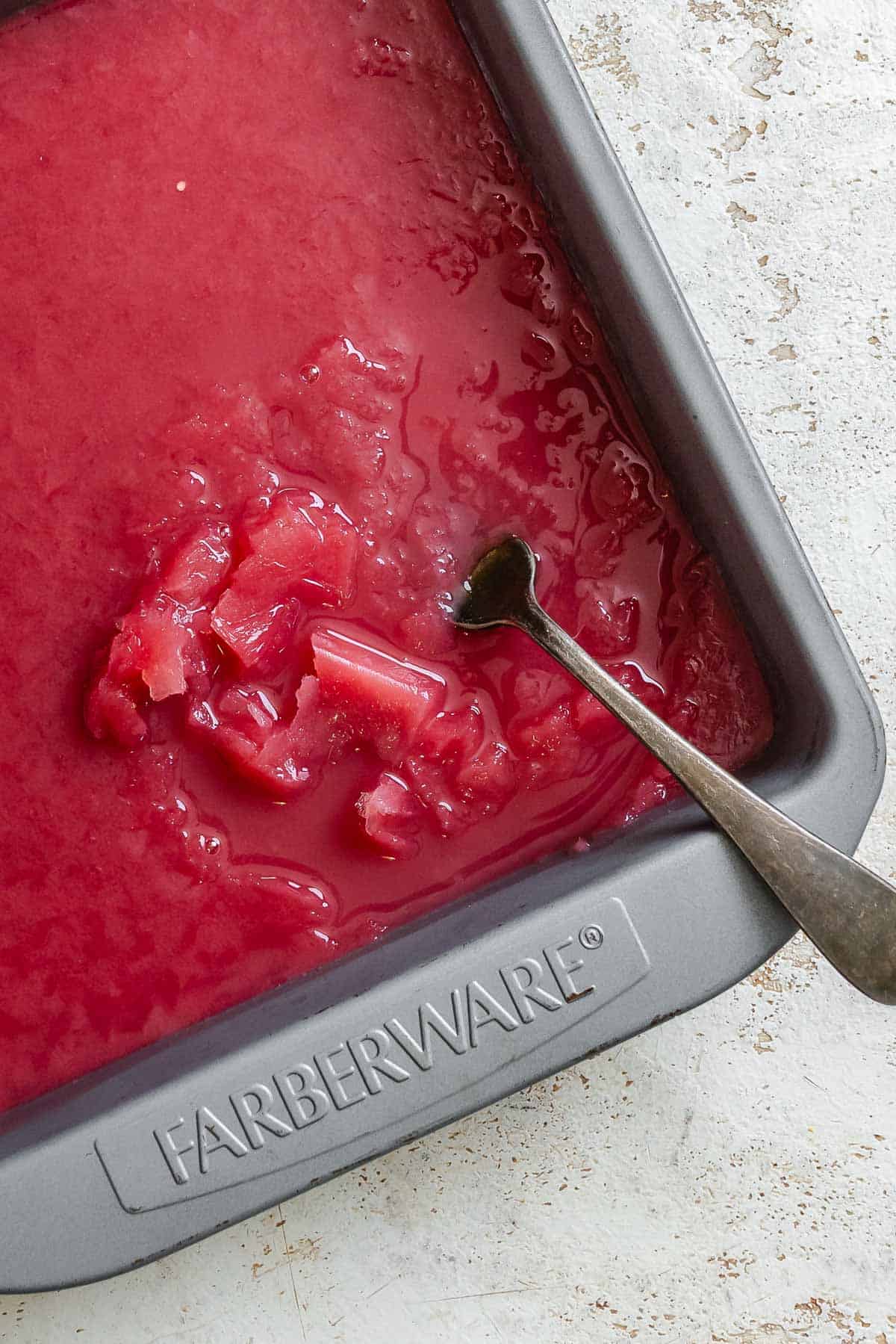 Process shot showing stirring ingredients in baking dish.
