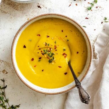 Completed Kabocha Squash Soup in two bowls on a white surface.