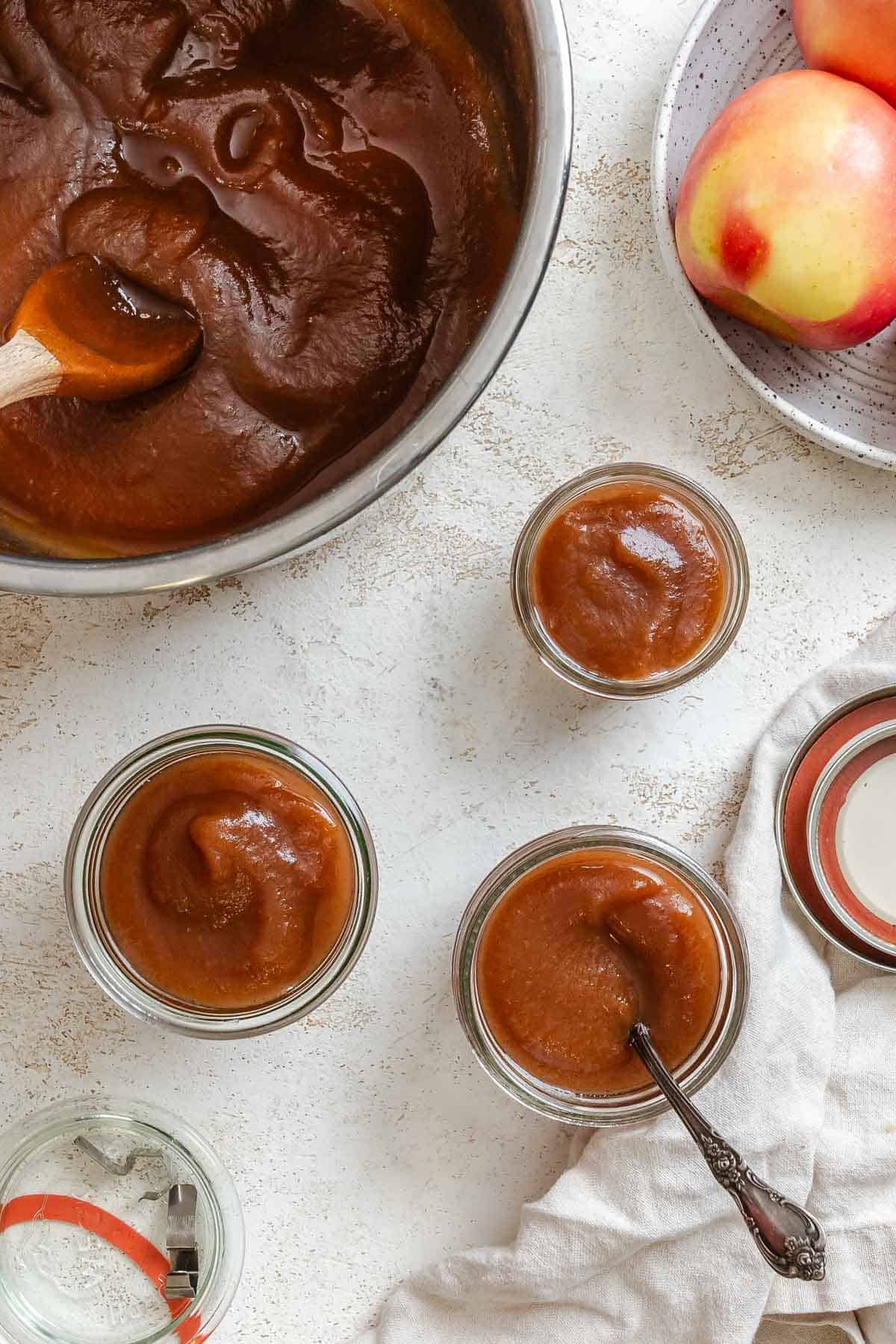 Process shot showing added apple butter to individual jars.