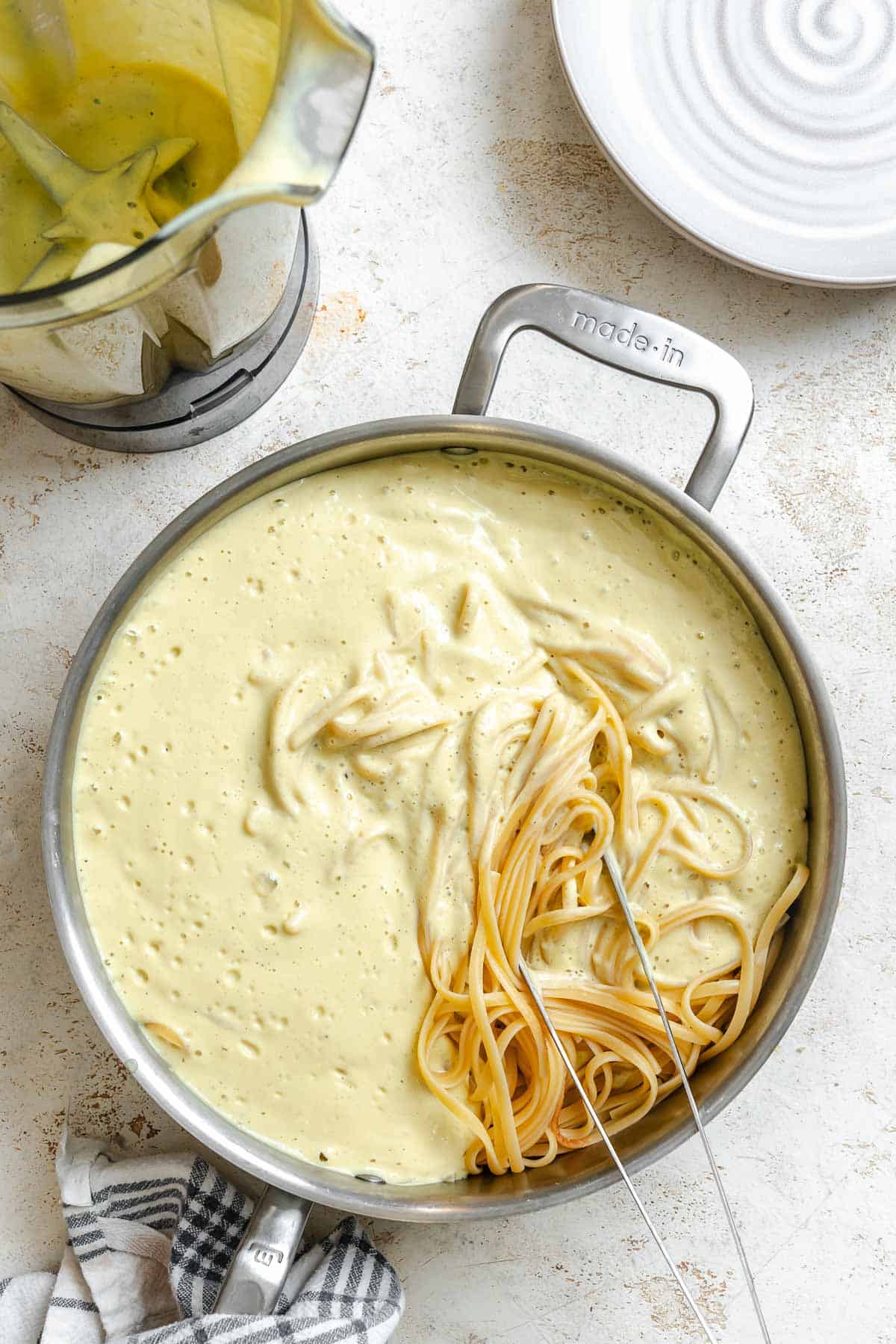 Process shot showing ingredients for Cauliflower Alfredo Sauce (Vegan) cooking in pot.