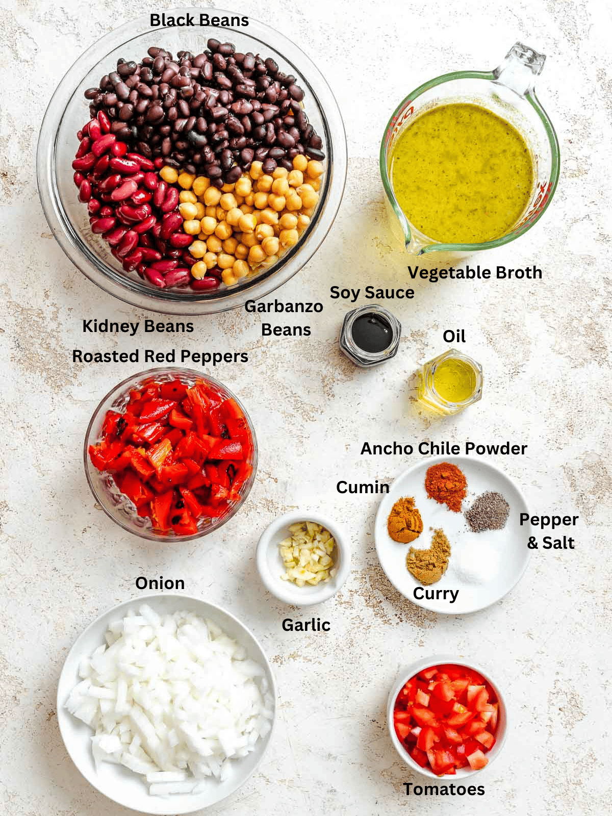 Ingredients for Easy Vegan Chili (With Roasted Bell Peppers) measured out on a white surface.