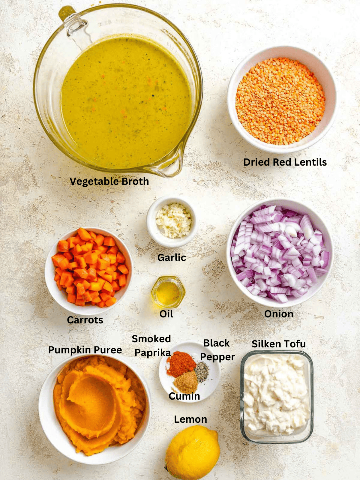 Ingredients for Lentil and Pumpkin Soup measured out on a white surface.