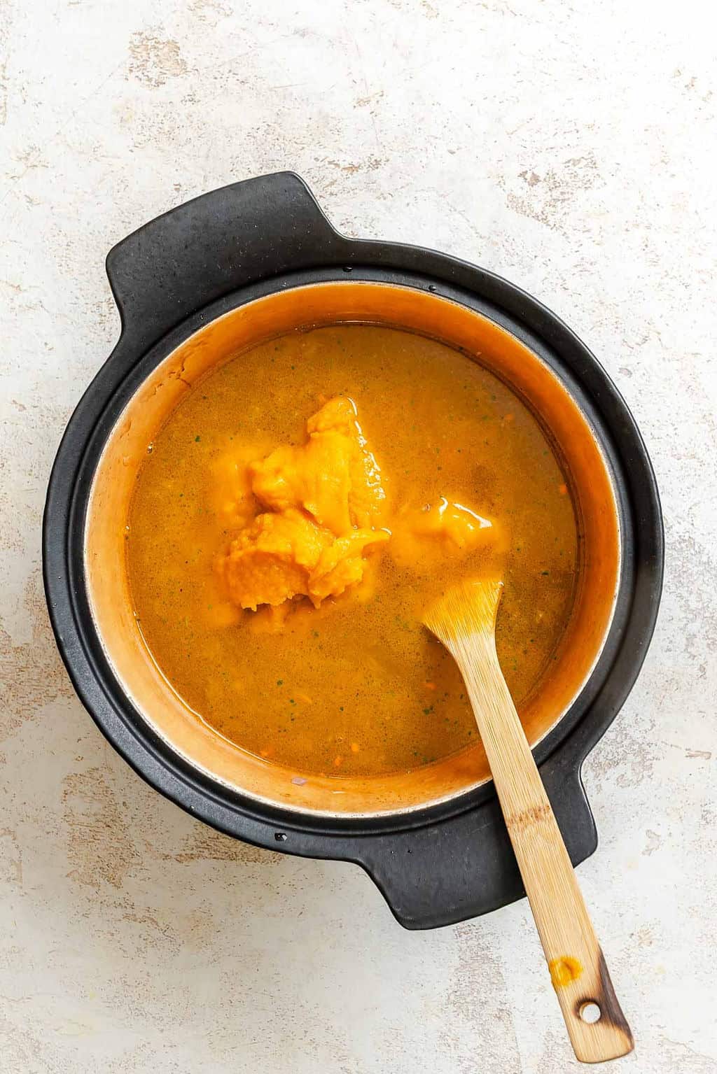 Process shot showing stirring ingredients in a pot.