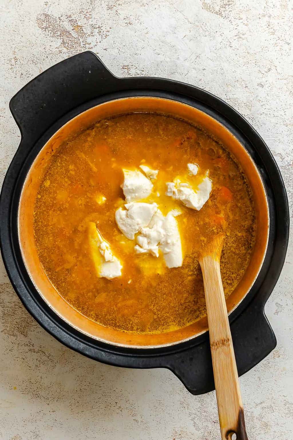 Silken tofu added to the cooked lentil and pumpkin soup in the pot.