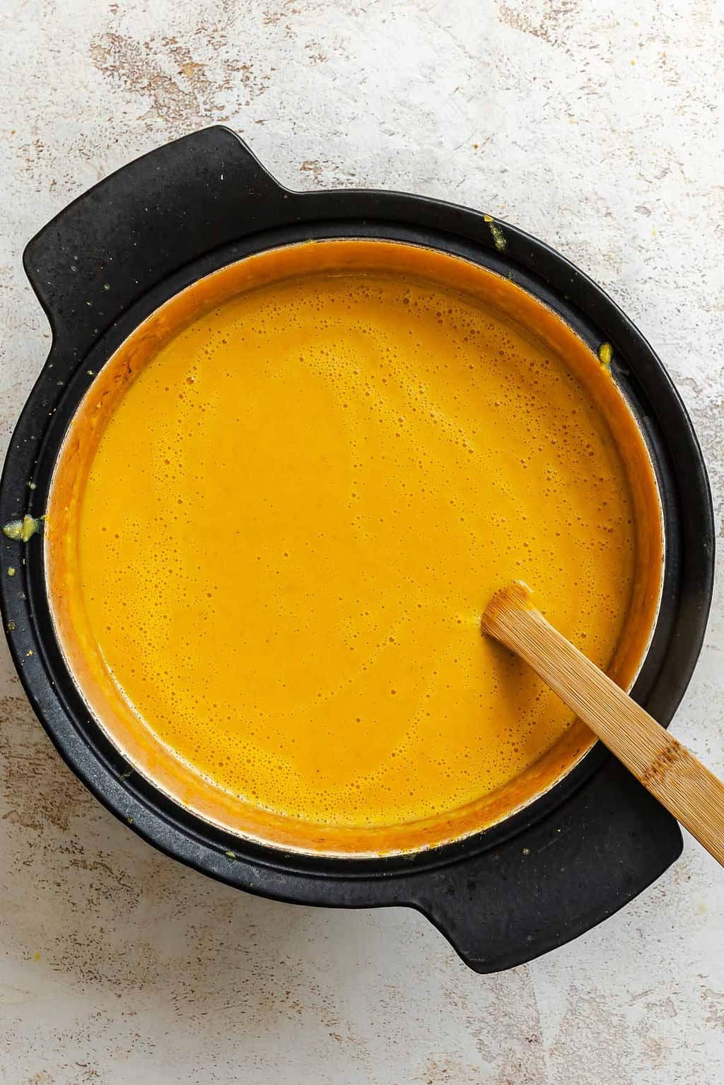 Process shot showing stirring ingredients in pot.
