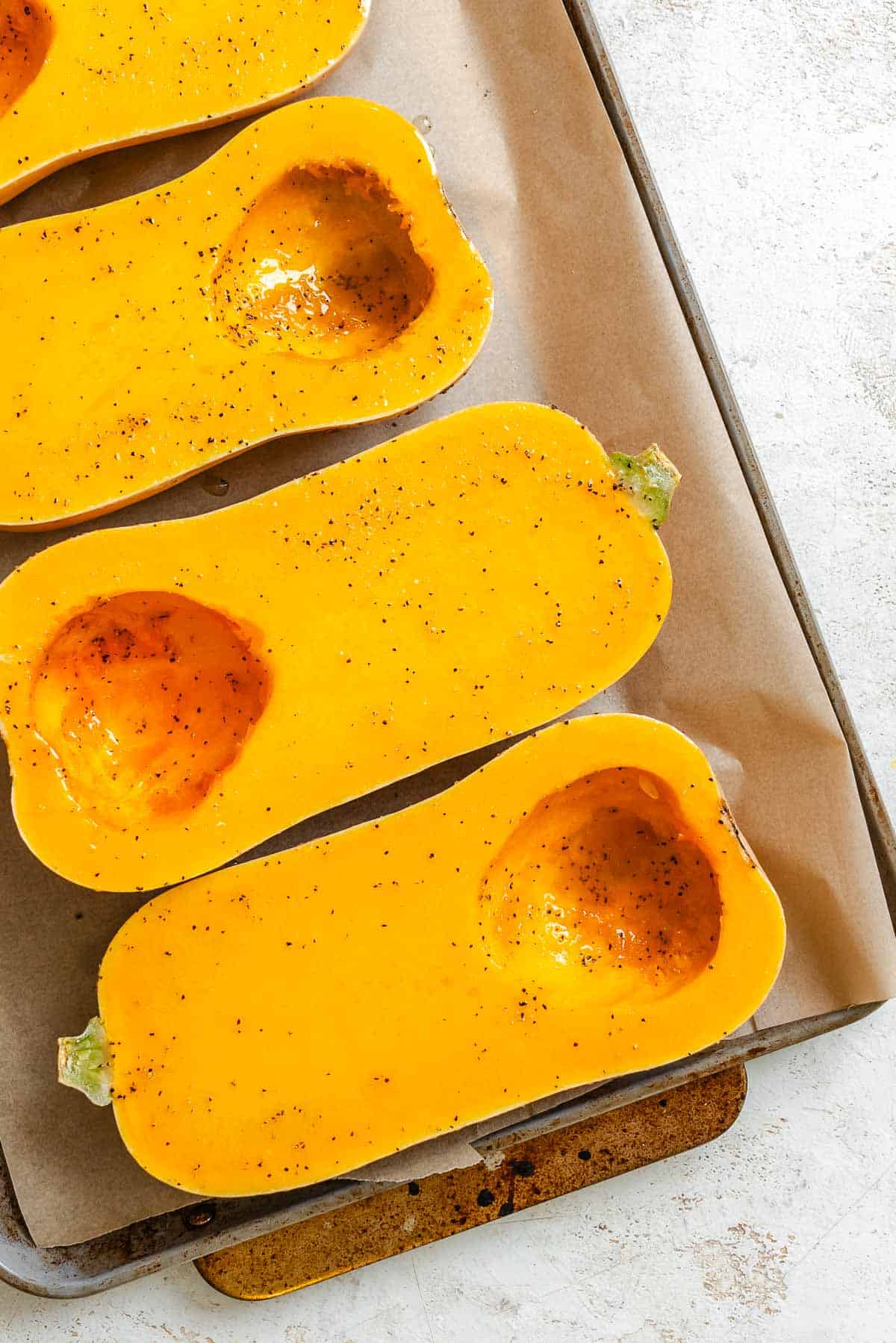 Process shot showing squash on a baking tray.