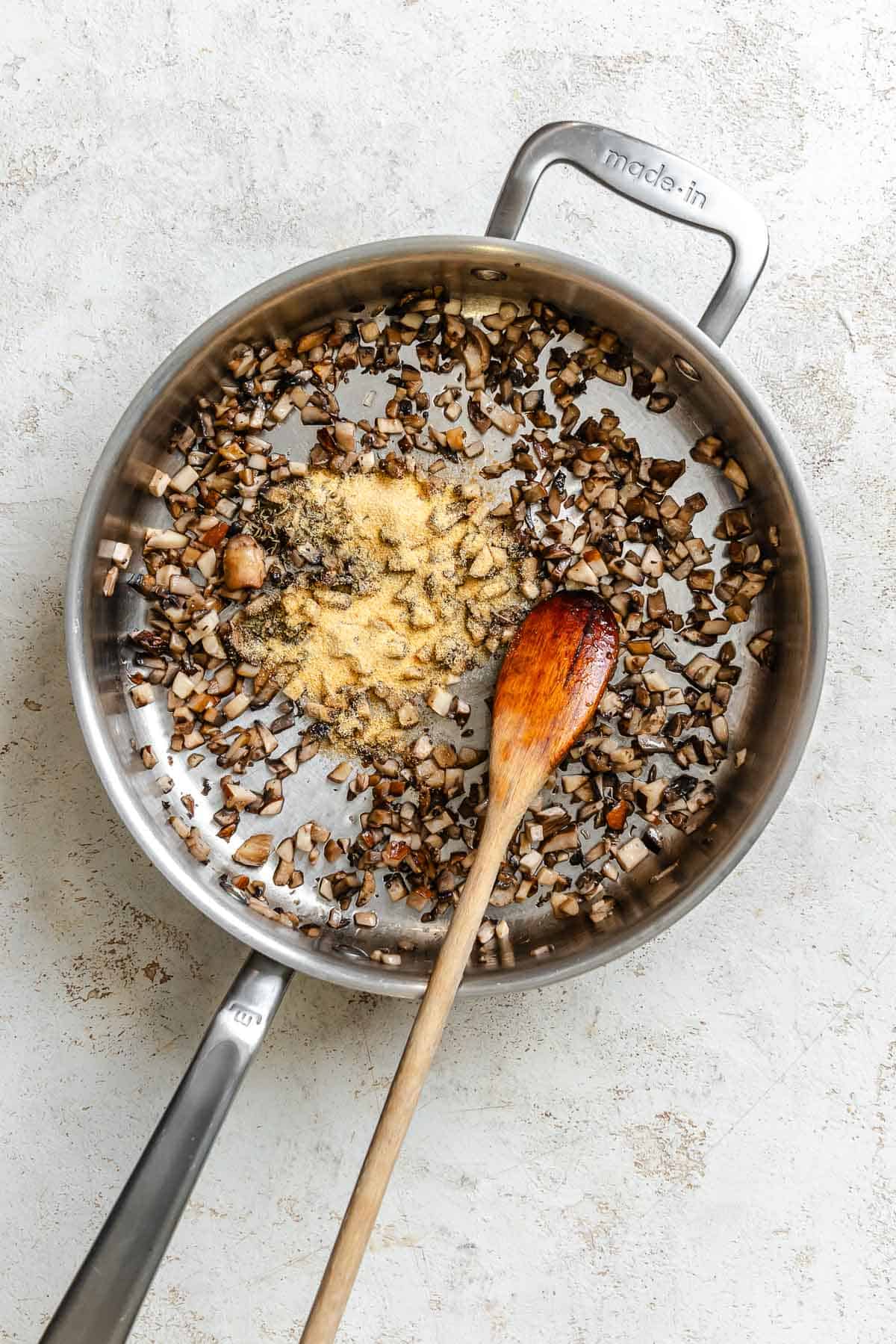 Process shot showing ingredients cooking in pan.